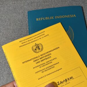 buku vaksin internasional berwarna kuning dan paspor