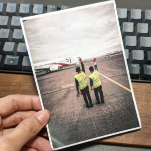 kartu pos bergambar ground crew melambaikan tangan ke pesawat Sriwijaya Air