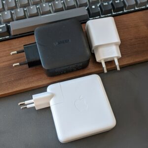 ukuran pengisi daya Ugreen GaN 65 W dibanding pengisi daya Apple MacBook Pro dan ponsel Google Pixel 4a