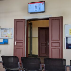 layar menampilkan nomor antrean di ruang tunggu Rathaus Pankow